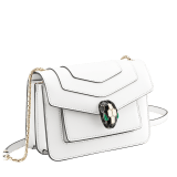 Serpenti Forever small crossbody bag in emerald green calf leather with amethyst purple grosgrain lining. Captivating snakehead closure in light gold-plated brass embellished with black and white agate enamel scales and green malachite eyes. 1082-CLa image 2