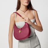 Serpenti Ellipse medium shoulder bag in Urban grain and smooth ivory opal calf leather with flamingo quartz pink gros grain lining. Captivating snakehead closure in gold-plated brass embellished with black onyx scales and red enamel eyes. 1190-UCL image 8