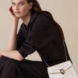 “Serpenti Forever” crossbody bag in agate-white calfskin with a polished, pearly finish and black grosgrain inner lining. Alluring snakehead closure in light gold-plated brass enriched with black and pearly, agate-white enamel and black onyx eyes 422-VCL image 5