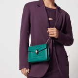 Serpenti Forever small crossbody bag in emerald green calf leather with amethyst purple grosgrain lining. Captivating snakehead closure in light gold-plated brass embellished with black and white agate enamel scales and green malachite eyes. 422-CLa image 1