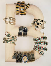 Multitude of different Serpenti Heritage watches enveloping a B in a Bulgari campaign from the 70s.