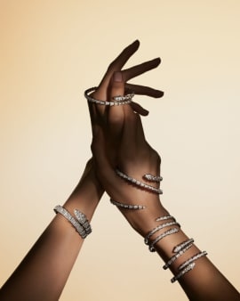 Serpenti Viper and Serpenti bracelets in white gold with diamonds coiling two arms, close up.