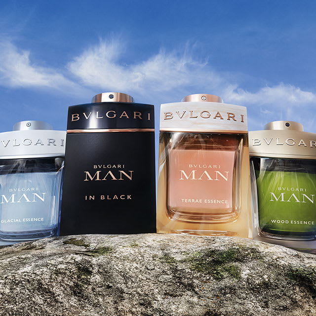 As quatro fragrâncias masculinas da coleção Bvlgari Man em frente a uma paisagem toscana.