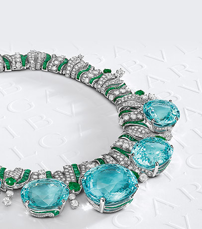 High Jewelry necklace with five Paraiba tourmalines, emeralds and diamonds, Bulgari logo backdrop.