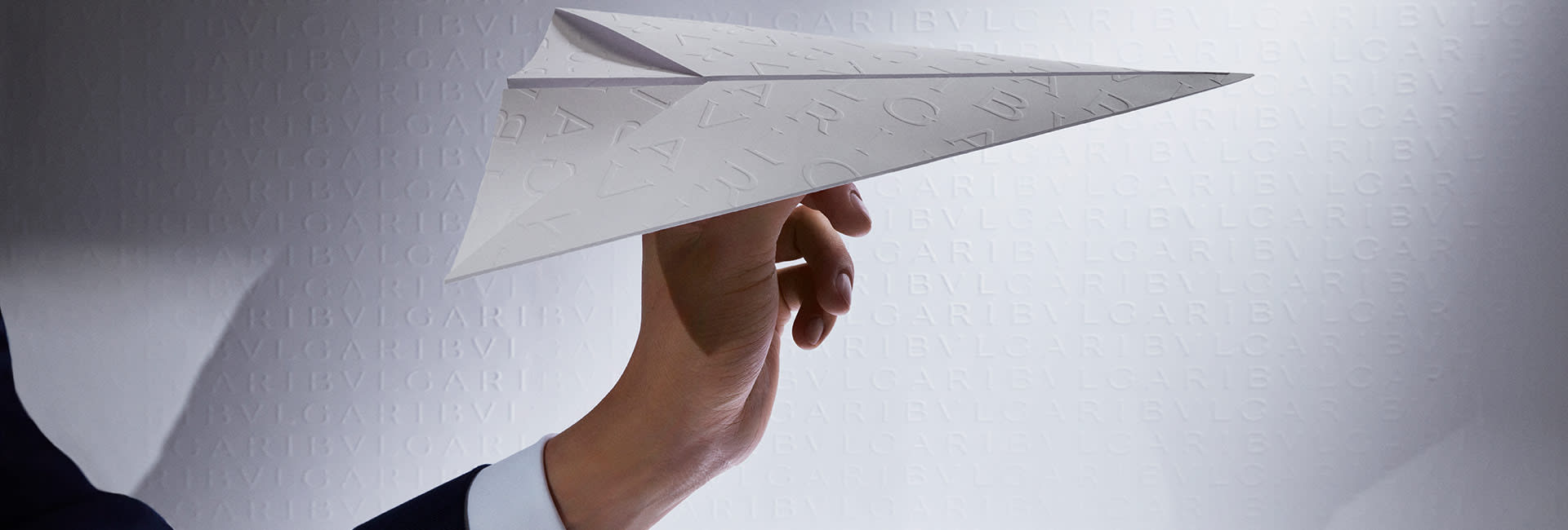 Hand holding a paper plane, symbolising Bulgari's complimentary gift message service.
