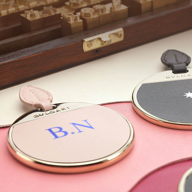 Personalized Bvlgari mirrors with pink and black leather inserts customized with initials.