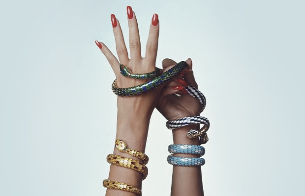 Models of different eras wearing Serpenti jewelry and the Bulgari B wrapped in Serpenti creations.
