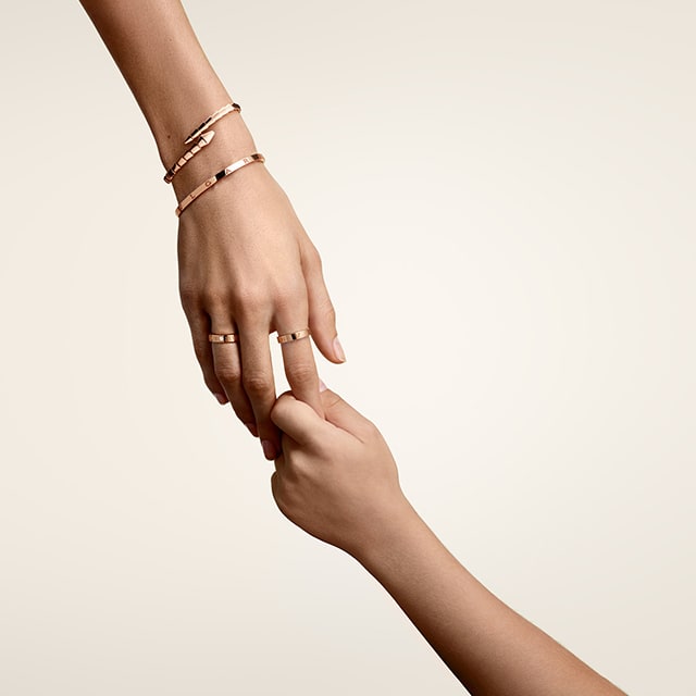 Hand wearing Bulgari Bulgari bracelet and ring and Serpenti bracelet.