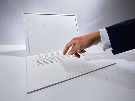 يدّ تتجه نحو جهاز كمبيوتر محمول بلون أبيض عليه شعار بولغري، تمثل انطباعاً بصرياً يعبِّر عن الأسئلة الشائعة لدى بولغري.