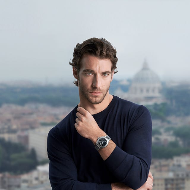 Lorenzo Viotti trägt die Octo Roma Chronograph Uhr aus Stahl mit schwarzem Zifferblatt vor einem römischen Hintergrund.