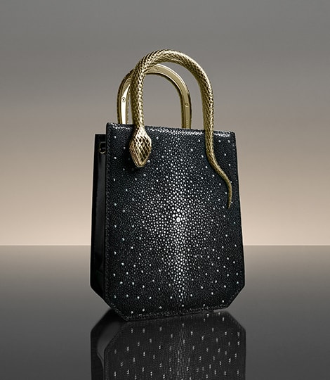 Serpentine系列钻石闪光黑色珍珠鱼皮竖款托特包，配有蛇形金属质感手柄。