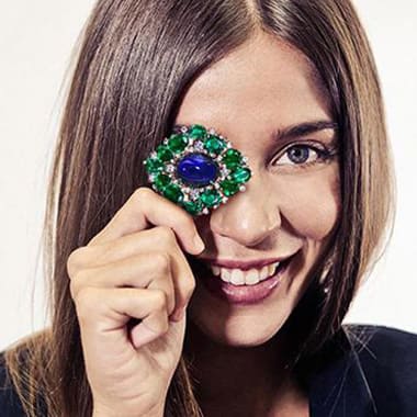 Model with amazing brooch with emeralds and sapphires