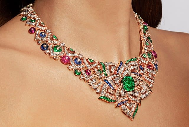 Model wearing the Oriental Buds Mediterranea High Jewelry rose gold necklace with emeralds, sapphires, pink tourmalines and diamonds, close-up.