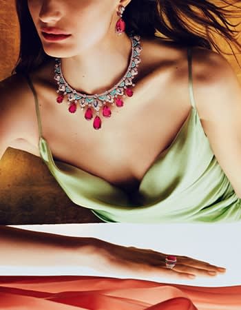 Model wearing High Jewellery platinum necklace with emeralds and diamonds.