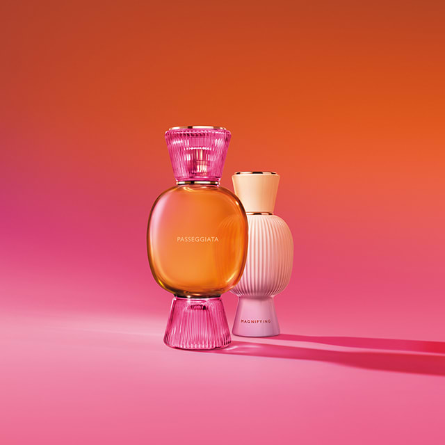 The all-white bottle of the Bvlgari Allegra Magnifying Essence, creative shot with colourful background.