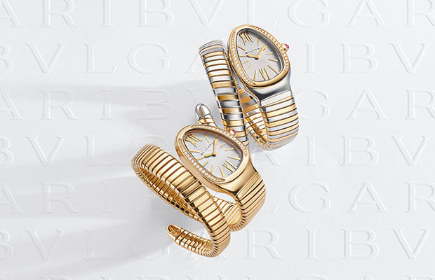 Serpenti Tubogas watches in rose gold and steel with diamonds on the bezel, white Bulgari logo backdrop.