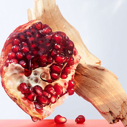 Pomegranate and cedar wood, the base notes of the Omnia Coral fragrance, creative shot.
