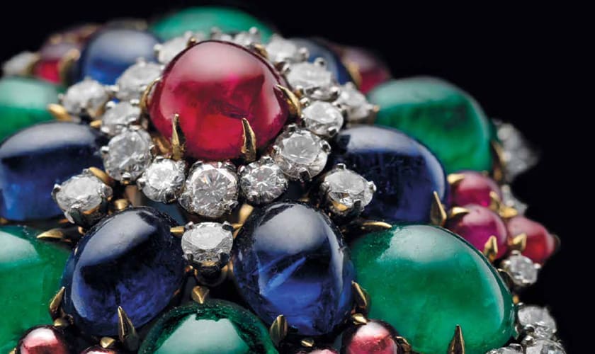 Bulgari heritage flower brooch with cabochon rubies, emeralds and sapphires, and diamonds, close up.