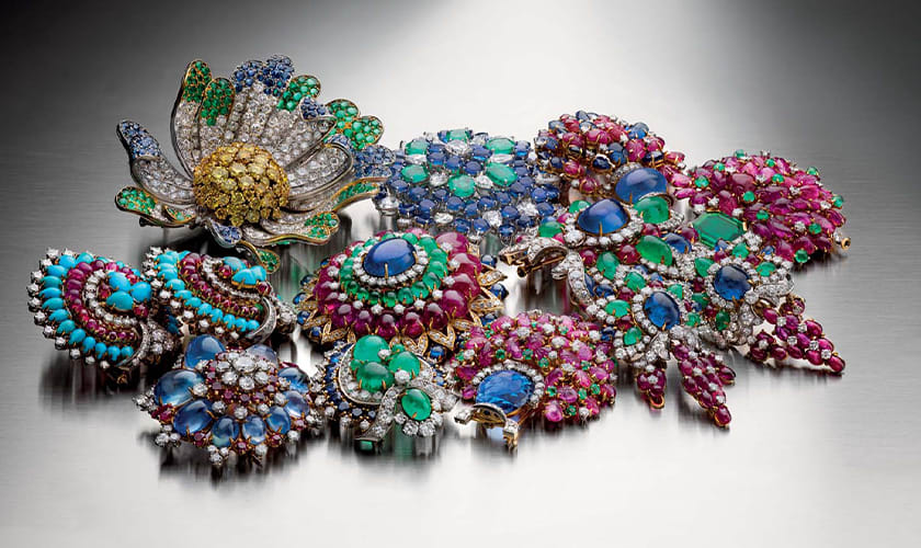 Multiple Bulgari Heritage brooches and earrings with cabochon cut coloured gemstones, creative shot.