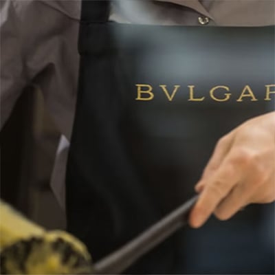 Hand in front of the Bulgari logo on a black backdrop symbolising Supplier Risk.