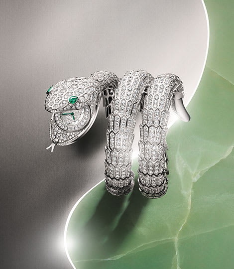 Serpenti Misteriosi High Jewelry white gold secret watch with diamonds and emerald eyes, creative shot.