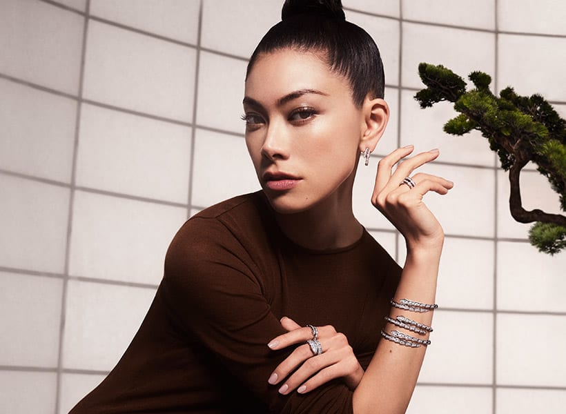 Hikari Mori from the side wearing white gold Serpenti Viper bangles, rings and earrings with diamonds.