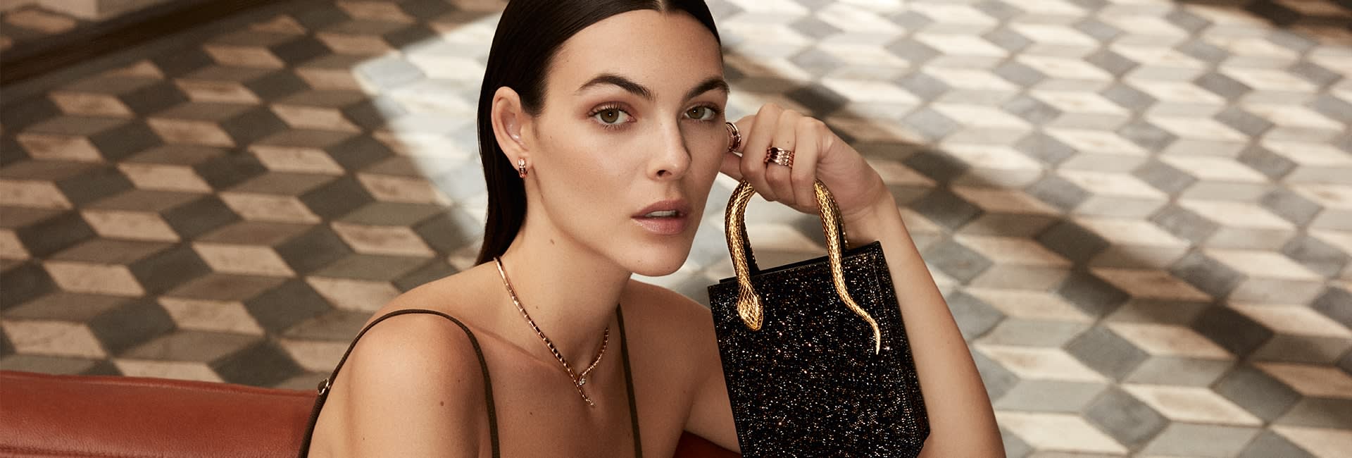 Vittoria Ceretti holding a black Serpentine Tote Crystal Sparkle bag with snake handle, Roman interior.