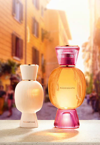 Transparent Omnia Crystalline fragrance bottle with Bulgari logo, sky backdrop, close-up.
