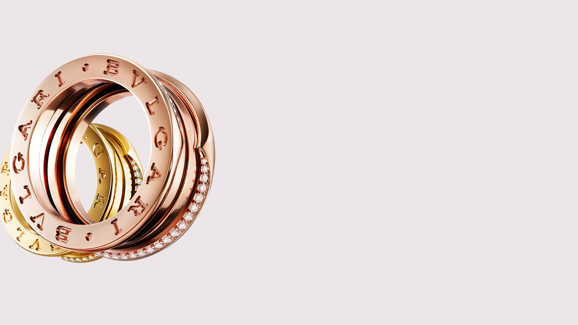 B.zero1 rings in 18 kt rose and yellow gold with demi pavé diamonds on the edges, close-up.