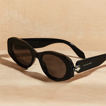 Serpenti Forever oval black acetate sunglasses with grey lenses and a snakehead on the temples.