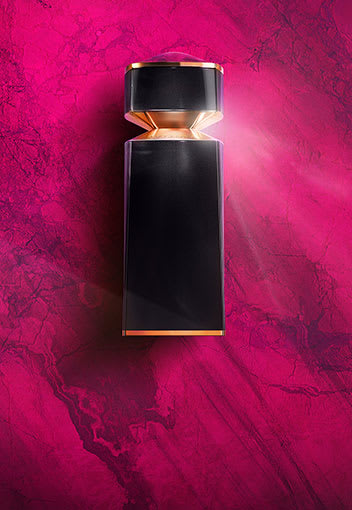 Black bottle of Bvlgari Le Gemme Sahare Eau de Parfum on purple backdrop evoking Pink Jasper.