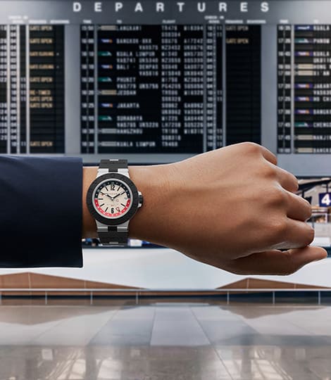 Bvlgari Aluminium GMT aus Aluminium und schwarzem Kautschuk, mit einer Abflugtafel im Hintergrund, bild2