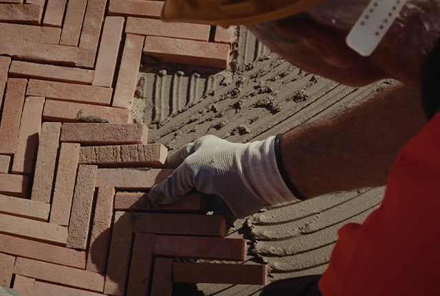 Craftsman assembling handmade tiles during the restoration of the Bulgari Hotel Roma, close up.