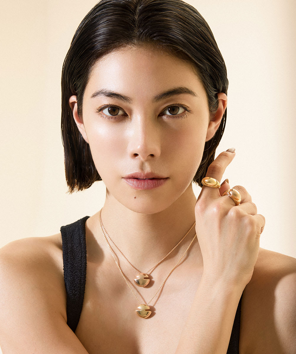 Model wearing Bulgari Cabochon rings in 18 kt yellow gold, close up.