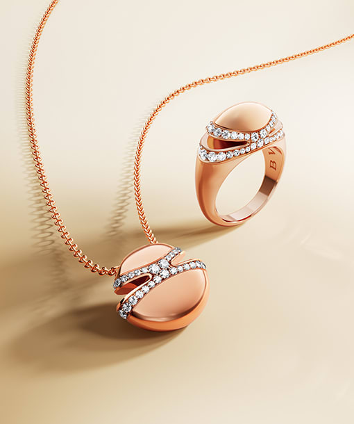 Bulgari Cabochon 18 kt yellow gold pendant necklace and ring, neutral backdrop.