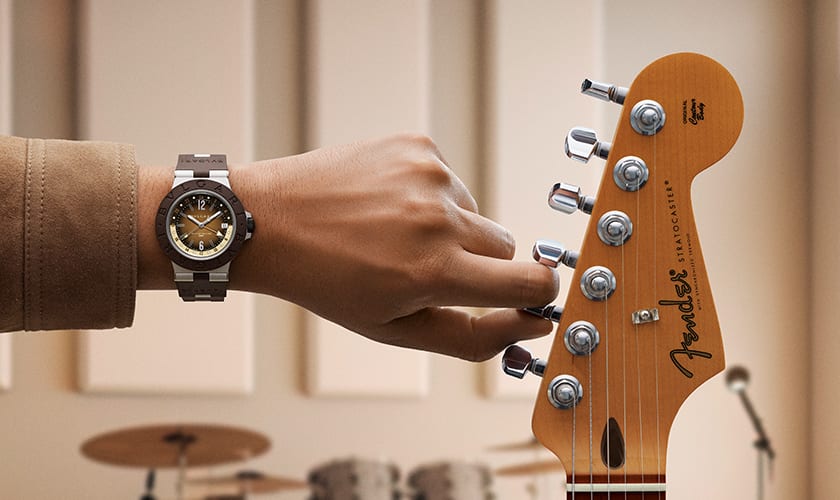 Bvlgari Aluminium GMT x Fender® Limited Edition watch on man's wrist and Stratocaster guitar, close up.