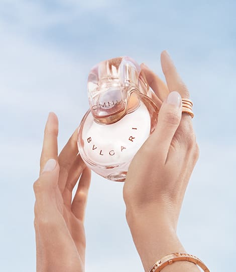 Powder pink transparent bottle of the Omnia Crystalline Eau de Parfum, blue sky in the background.