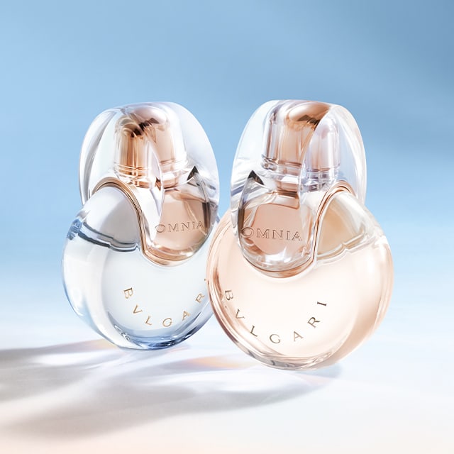 Omnia Crystalline, Omnia Amethyste and Omnia Coral fragrance bottles against a white, purple and red background.