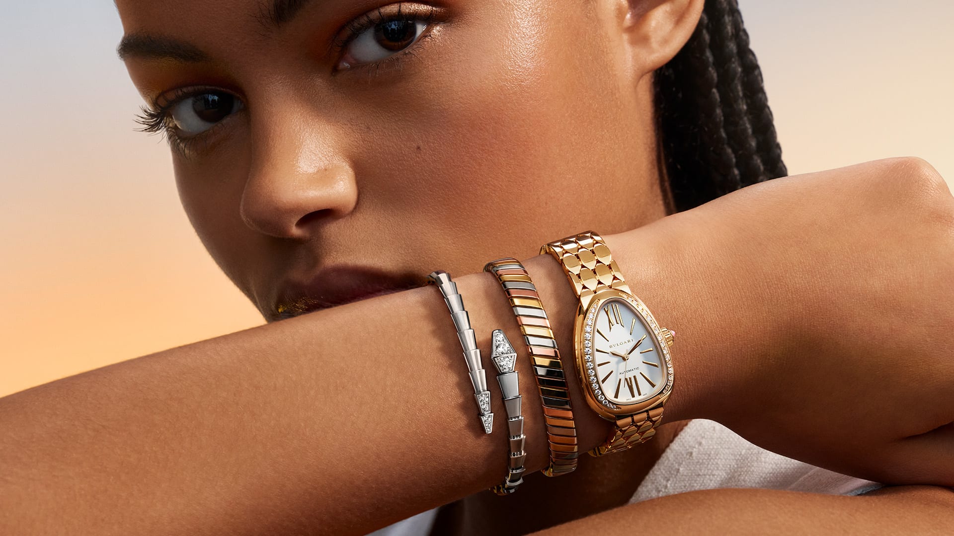 Model wearing Serpenti Seduttori watch and Bvlgari Tubogas and Serpenti bracelets.