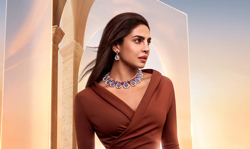 Priyanka Chopra Jonas wearing Bvlgari High Jewellery, dawn sky and Roman architecture in the background.