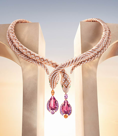 Serpenti High Jewelry necklace set against Roman architectural elements, dawn sky in the background.