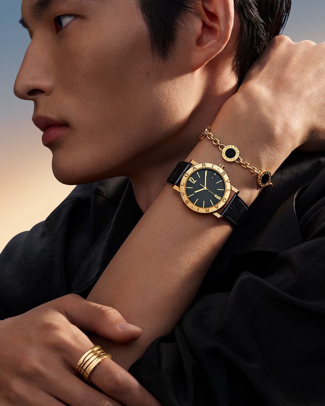 Model wearing a Bvlgari Bvlgari yellow gold necklace with onyx and mother of pearl inserts, close up.