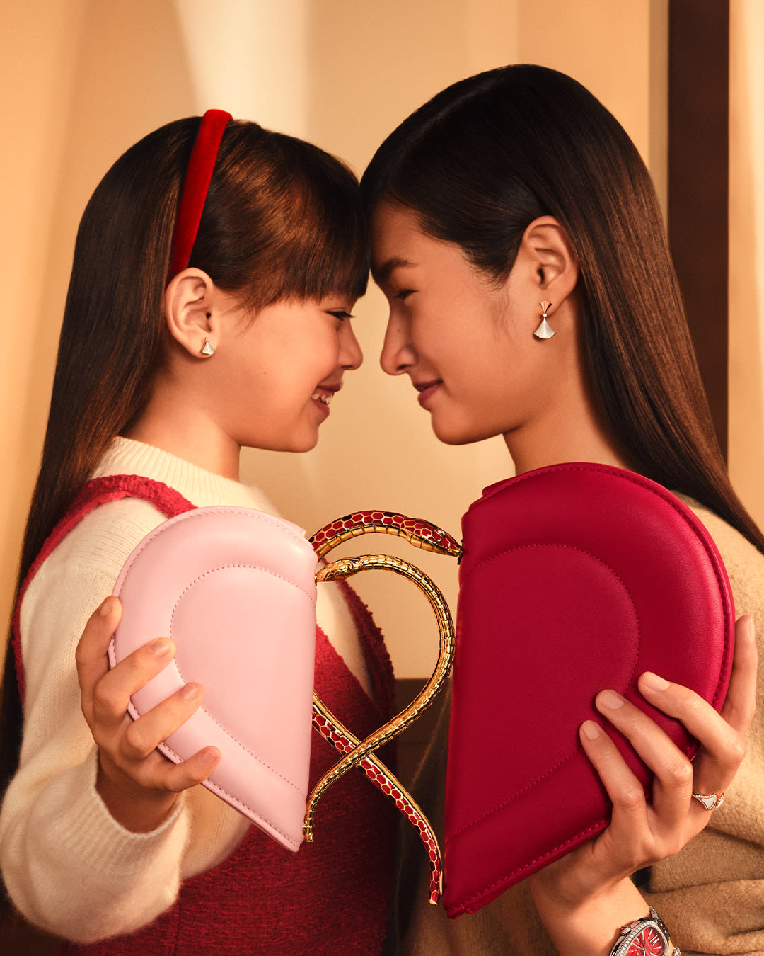 Models holding Serpenti Cuoricino mini bag.