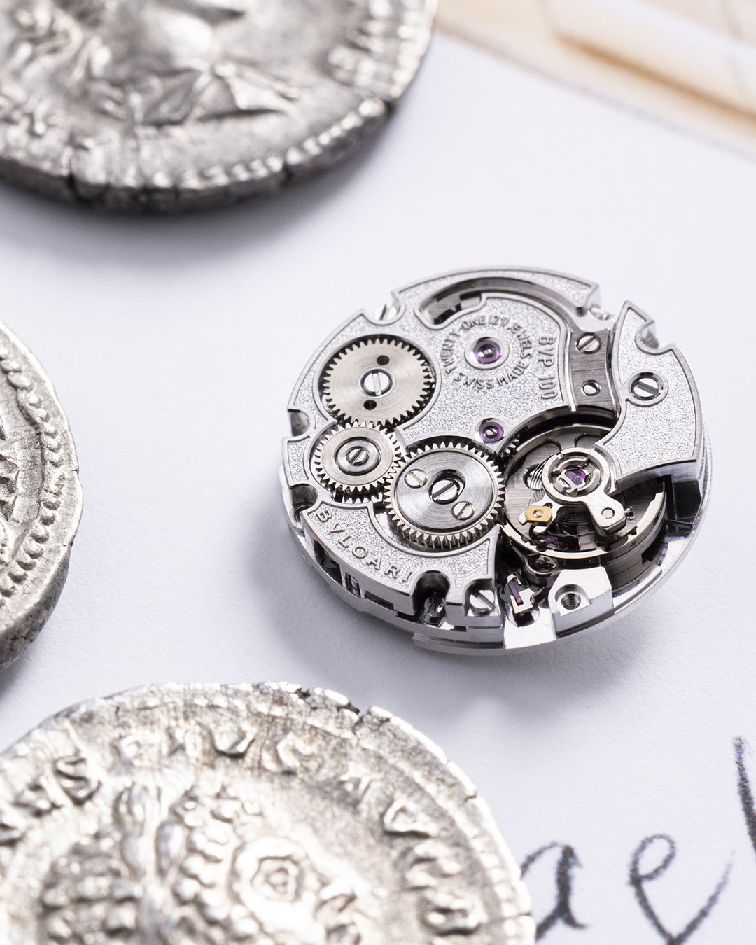 Ancient coin placed on the Maglia Milanese Monete secret watch sketch, close up.