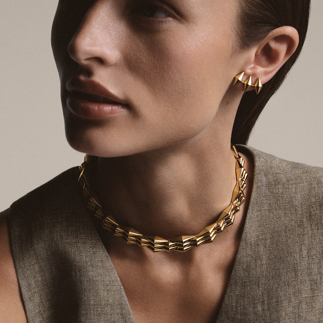 Model wearing Vimini 18 kt yellow gold necklace and earrings, Bvlgari Eternal jewellery collection.