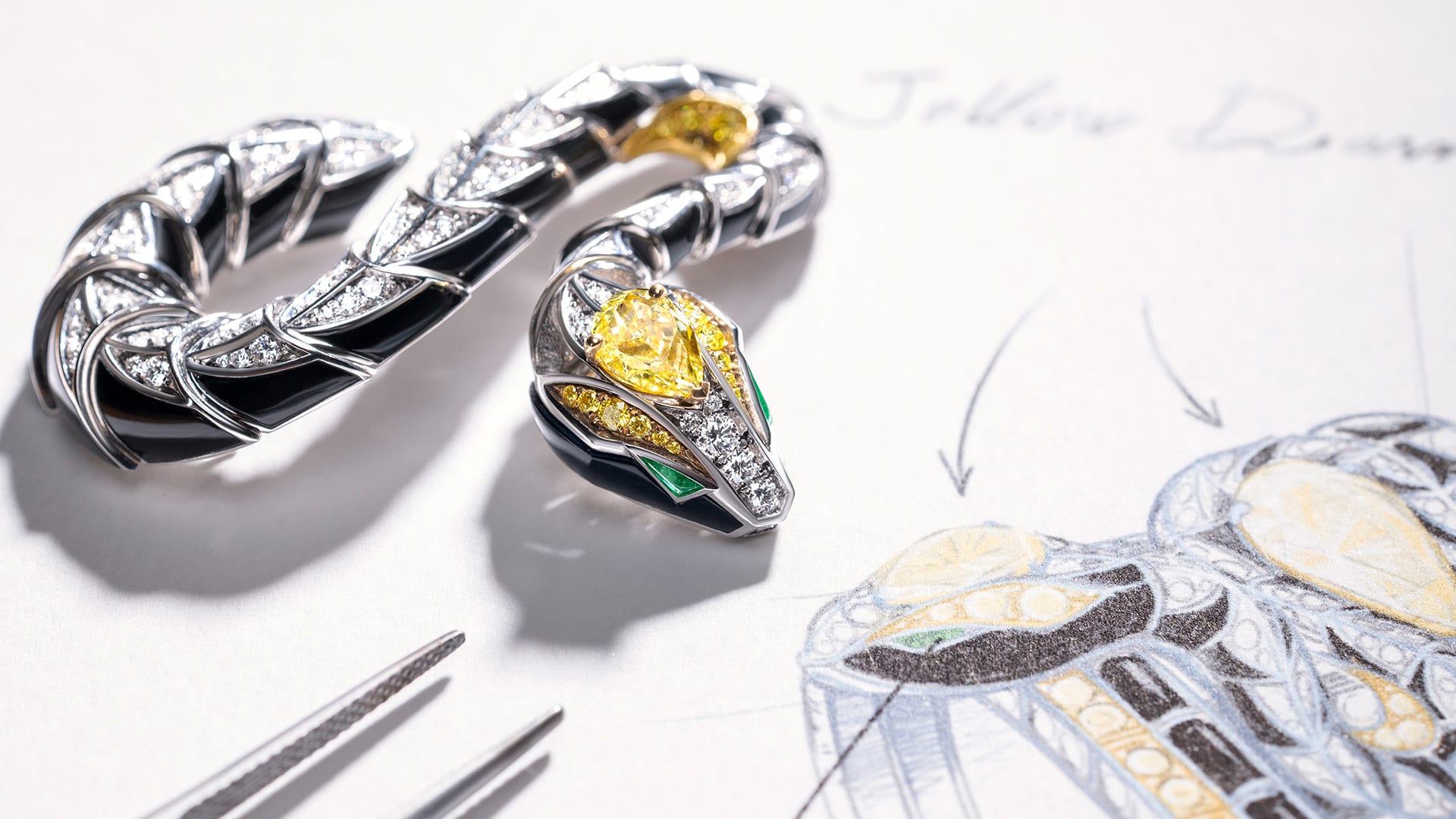 Detail of Serpenti Spira High Jewellery white gold cuff with yellow diamonds and onyx, sketch behind.