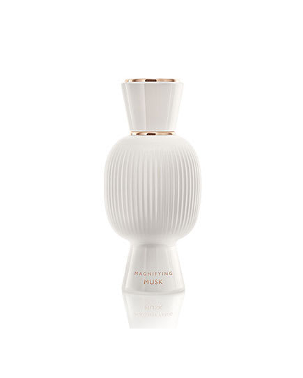 White flacon of the Bvlgari Allegra Magnifying Musk essence in front of white crystals, creative shot.