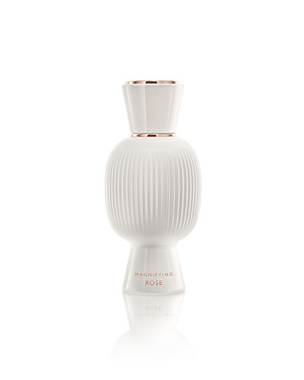 White flacon of the Bvlgari Allegra Magnifying Rose essence in front of a pink rose, creative shot.