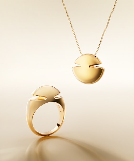 Bulgari Cabochon 18 kt yellow gold pendant necklace and ring, neutral backdrop.
