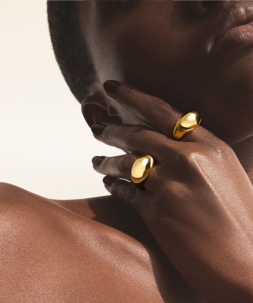 Model wearing Bulgari Cabochon rings in 18 kt yellow gold, close up.